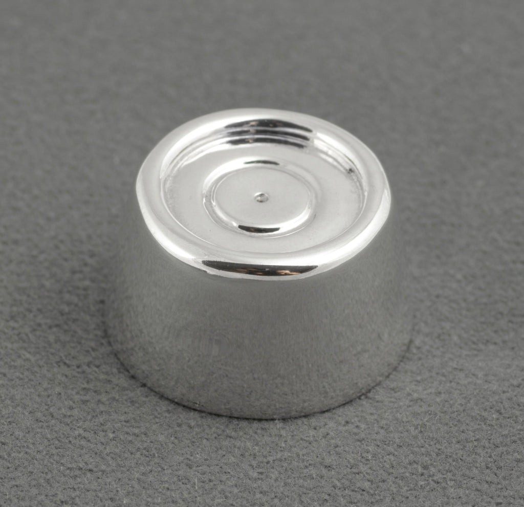 Sterling silver My Last Rolo keepsake - Sheffield 2003 - C. W. Sellors - top view on grey background showing tapered cylindrical form with recessed circular top and concentric ring detail at centre