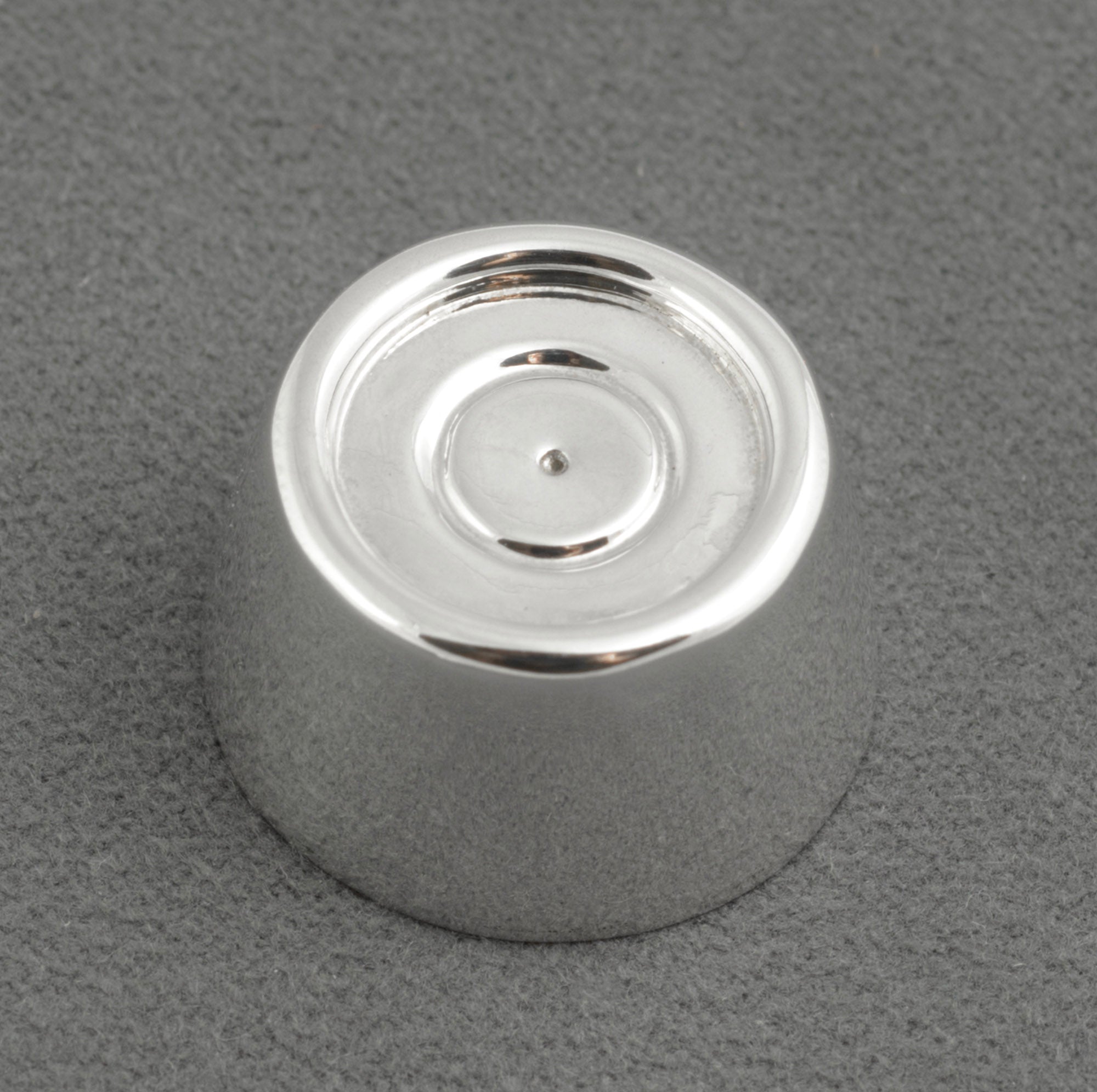 Sterling silver My Last Rolo keepsake - Sheffield 2003 - C. W. Sellors - angled top view on grey background showing tapered cylindrical form with recessed circular top concentric ring detail and high polish finish to sides