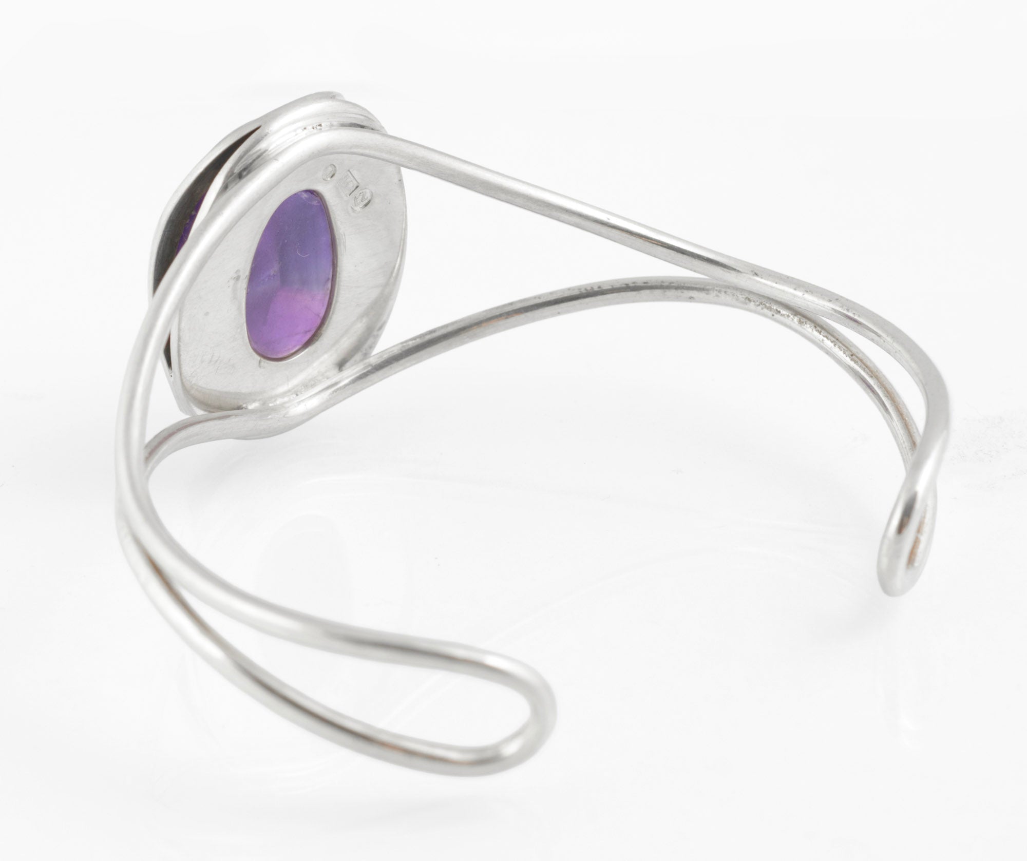 Vintage sterling silver amethyst cabochon bangle - Polish handmade - Gdańsk 925 - side profile view on white background showing height of domed amethyst cabochon above bezel and wire arm profile with scrolled terminal
