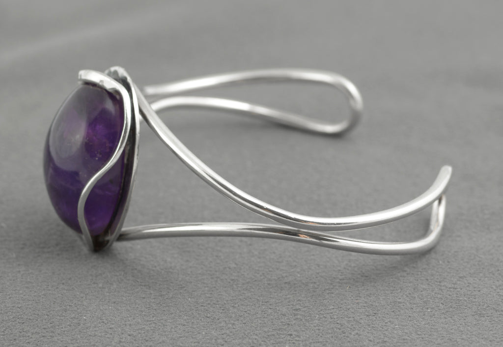 Vintage sterling silver amethyst cabochon bangle - Polish handmade - Gdańsk 925 - angled front view on white background showing two parallel wire arms and scrolled open ends with large natural amethyst cabochon centrally set