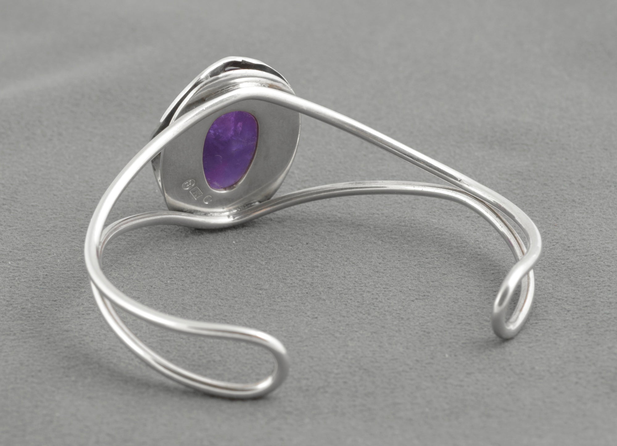 Vintage sterling silver amethyst cabochon bangle - Polish handmade - Gdańsk 925 - side profile view on white background showing depth of high domed amethyst cabochon above wire form setting and parallel wire arm construction