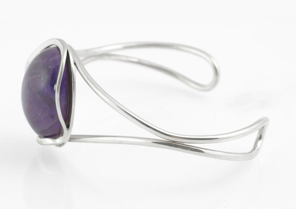 Vintage sterling silver amethyst cabochon bangle - Polish handmade - Gdańsk 925 - three-quarter rear view on white background showing parallel wire construction scrolled ends and open back bezel with amethyst cabochon visible from reverse
