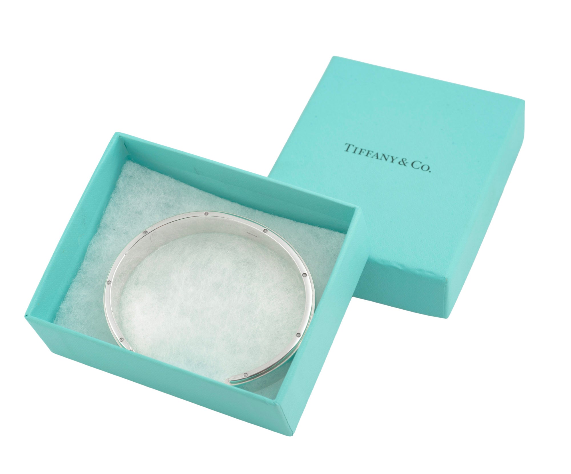 Tiffany and Co Metropolis sterling silver cuff bangle - 925 - three-quarter front view on grey background showing wide flat top face with raised central section recessed channels and screw head edge detail