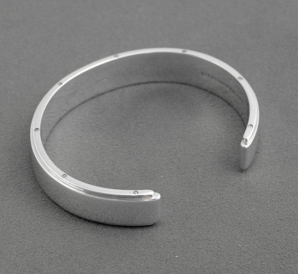 Tiffany and Co Metropolis sterling silver cuff bangle - 925 - underside view on grey background showing full circumference of screw head edge detail and inner rounded profile of cuff