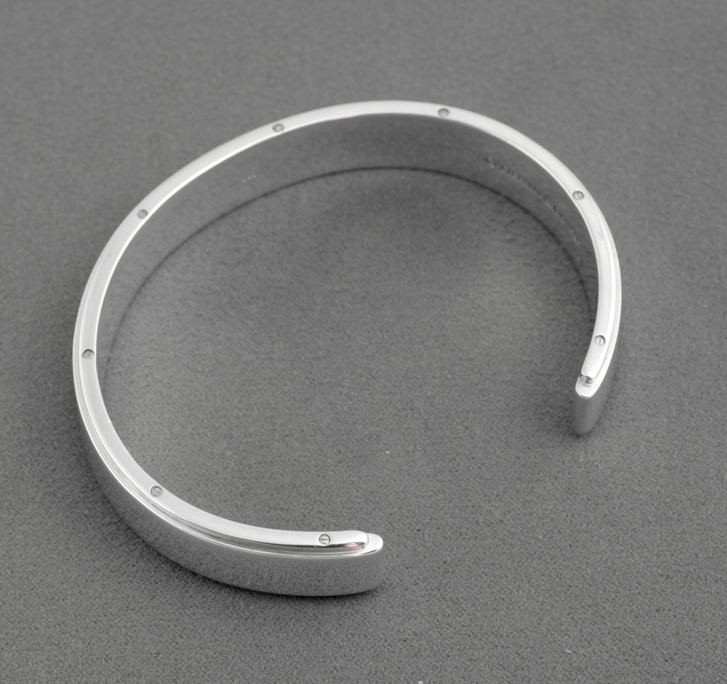 Tiffany and Co Metropolis sterling silver cuff bangle - 925 - close up of inner face on grey background showing engraved copyright Tiffany and Co 925 hallmark and screw head detail to upper edge