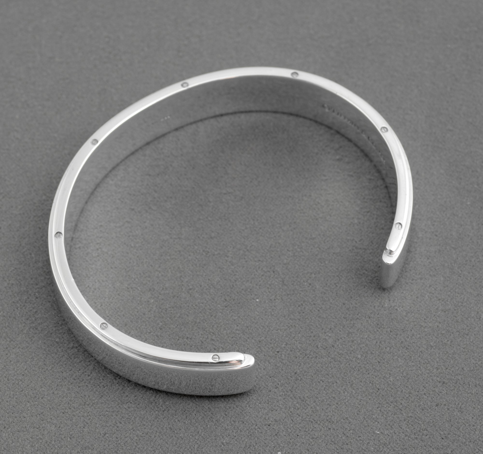 Tiffany and Co Metropolis sterling silver cuff bangle - 925 - close up of inner face on grey background showing engraved copyright Tiffany and Co 925 hallmark and screw head detail to upper edge