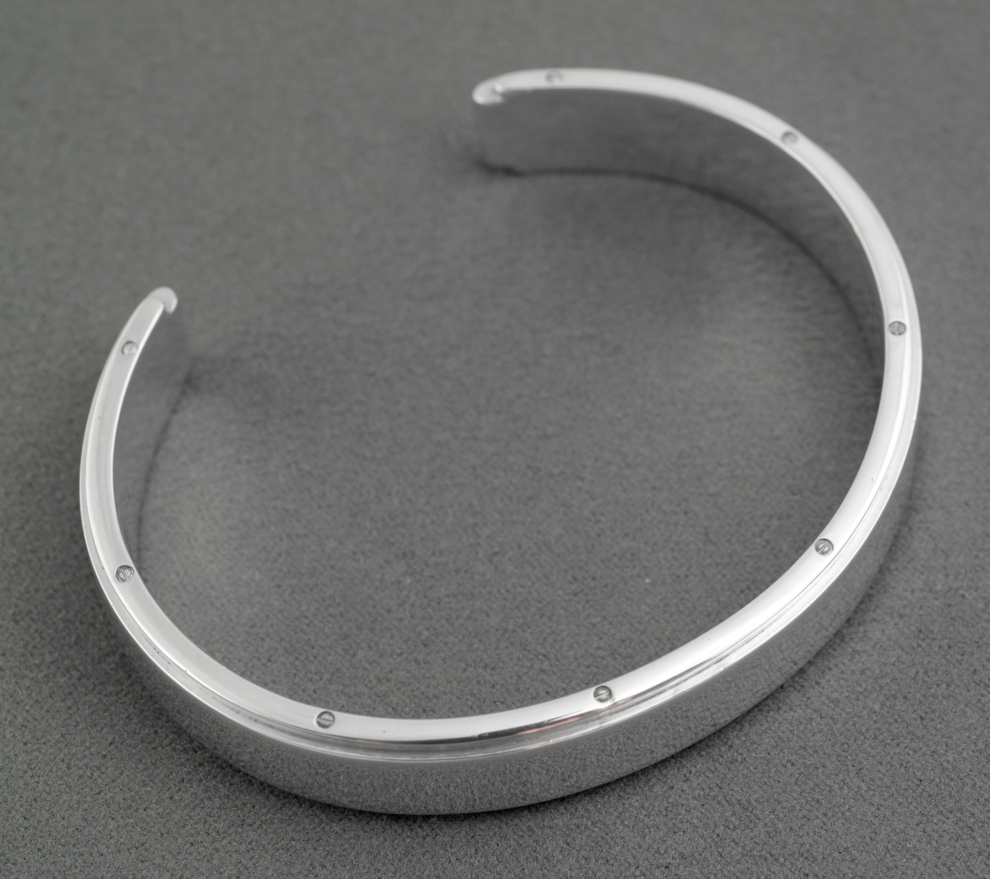 Tiffany and Co Metropolis sterling silver cuff bangle - 925 - side profile view on grey background showing width of flat top face raised central section and rounded inner edge profile