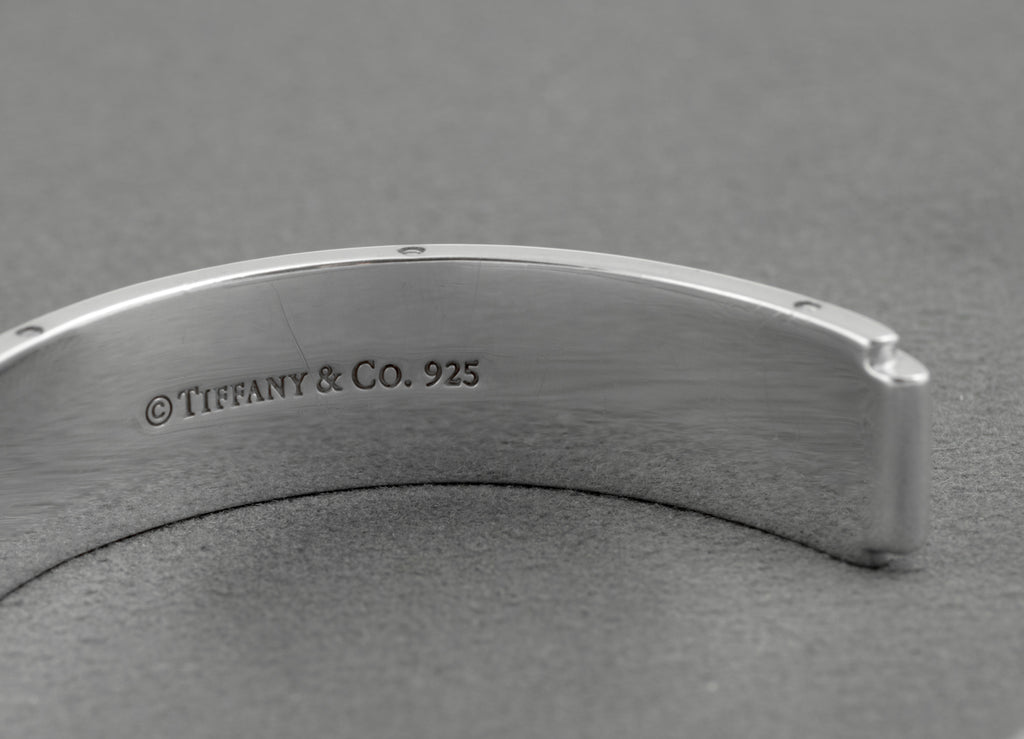 Tiffany and Co Metropolis sterling silver cuff bangle - 925 - angled rear view on grey background showing inner rounded profile screw head edge detail and open cuff form
