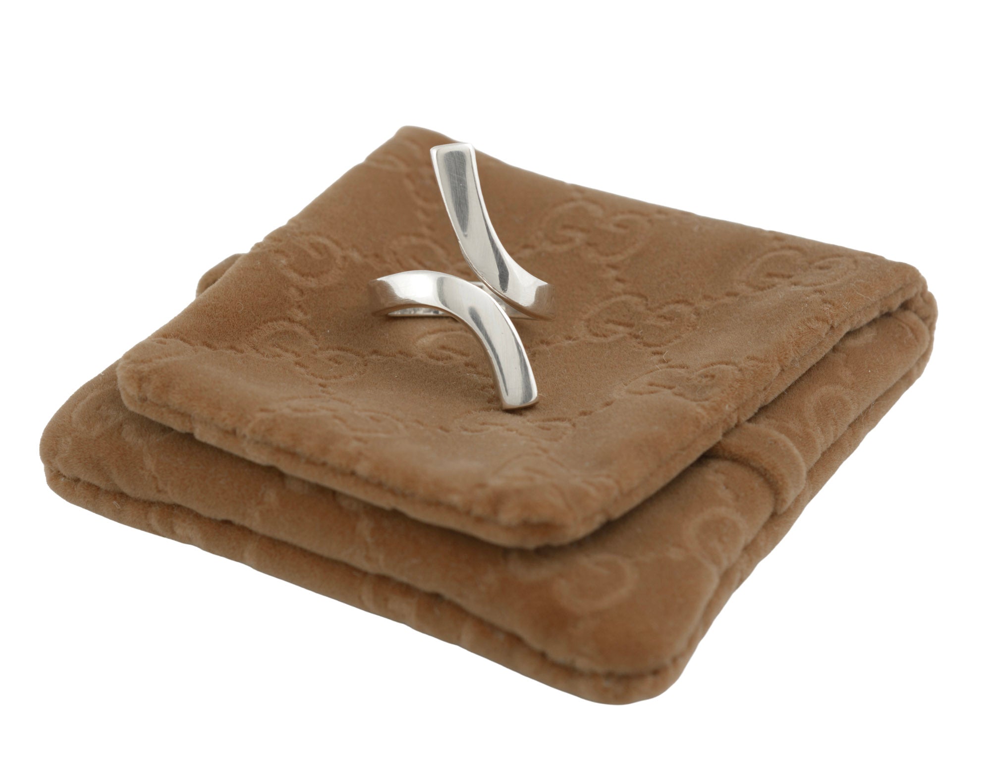 Vintage Gucci Chiodo sterling silver crossover bar ring on Gucci GG monogram pouch showing angled view of crossover bar form with Gucci engraving visible to upper bar face