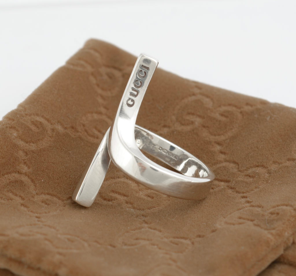 Vintage Gucci Chiodo sterling silver crossover bar ring worn on index finger showing crossover bar form and Gucci engraving to upper bar face against white background