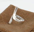 Vintage Gucci Chiodo sterling silver crossover bar ring worn on index finger showing crossover bar form and Gucci engraving to upper bar face against white background