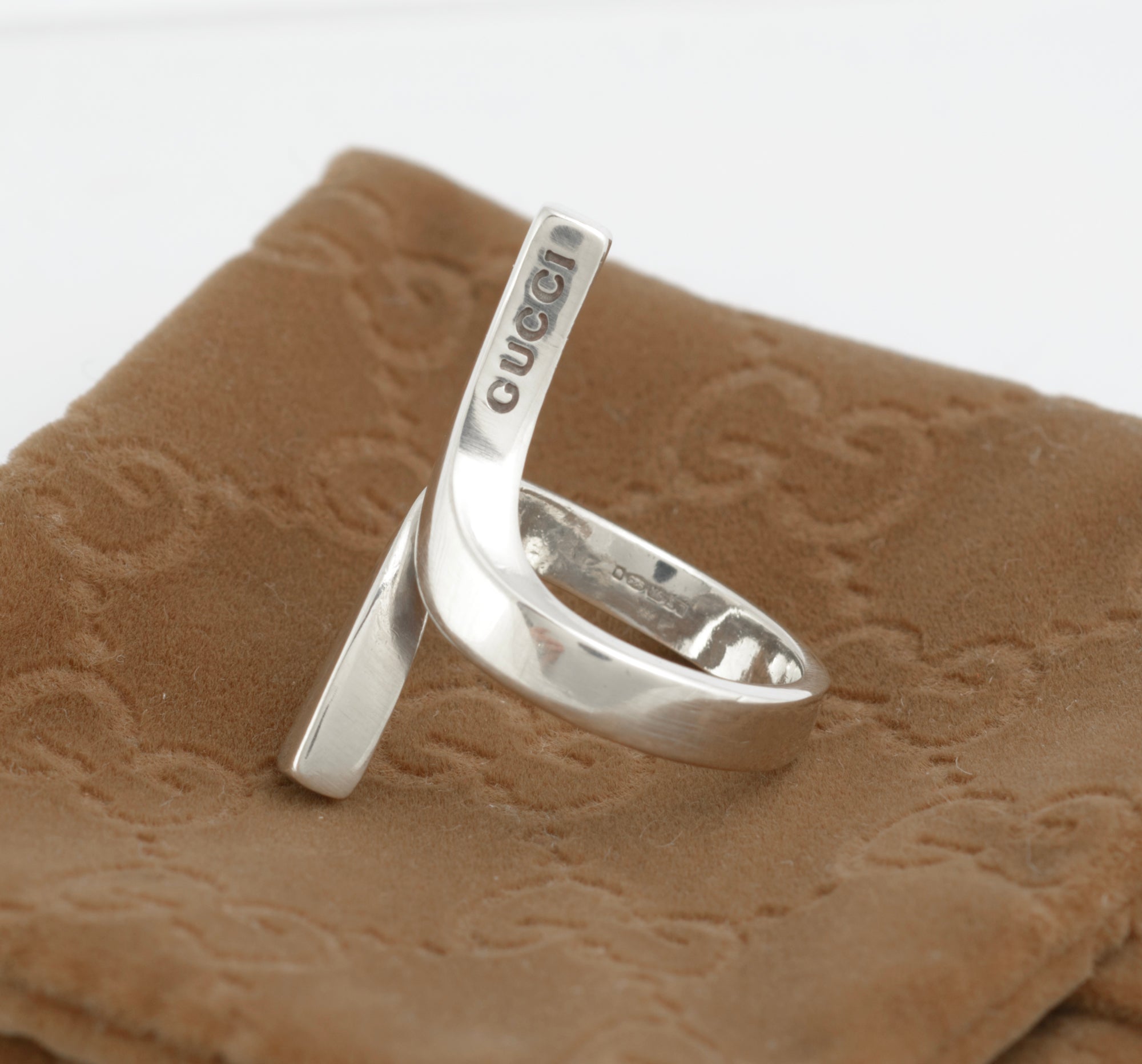 Vintage Gucci Chiodo sterling silver crossover bar ring worn on index finger showing crossover bar form and Gucci engraving to upper bar face against white background