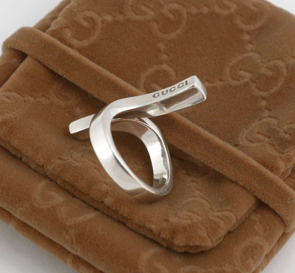 Vintage Gucci Chiodo sterling silver crossover bar ring worn on middle finger showing side profile of crossover bar form and Gucci engraving to lower bar face
