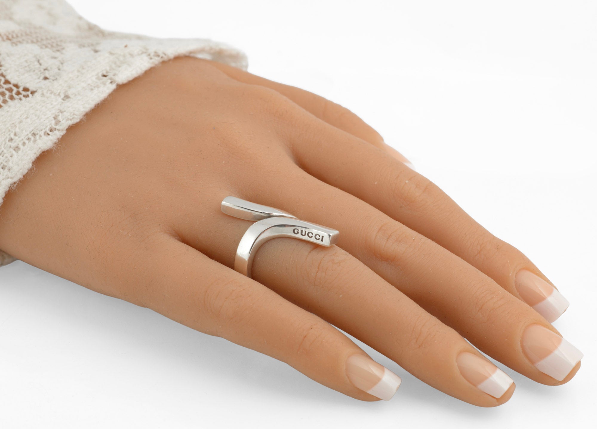 Vintage Gucci Chiodo sterling silver crossover bar ring worn on middle finger showing reverse side profile of crossover bar form and plain polished band