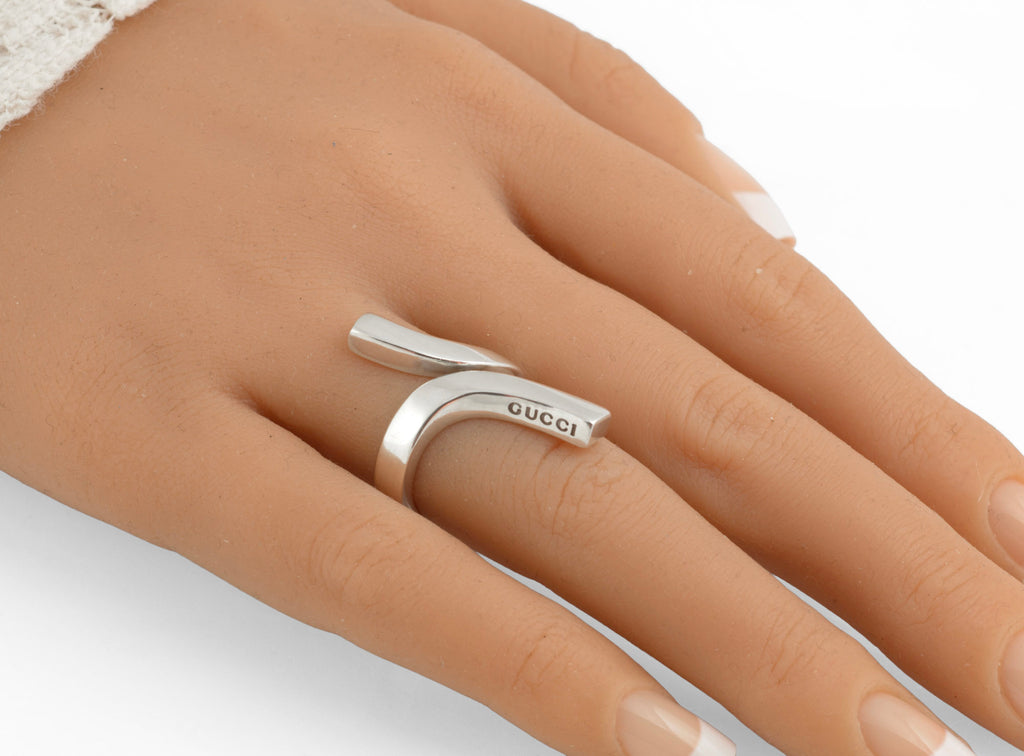 Vintage Gucci Chiodo sterling silver crossover bar ring on white background showing top view of crossover bar form with Gucci engraving and broad polished band