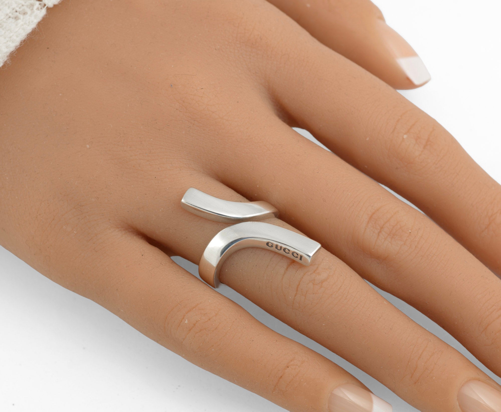Vintage Gucci Chiodo sterling silver crossover bar ring on white background showing inner band with London assay hallmark and Italian silver hallmark with silversmiths mark