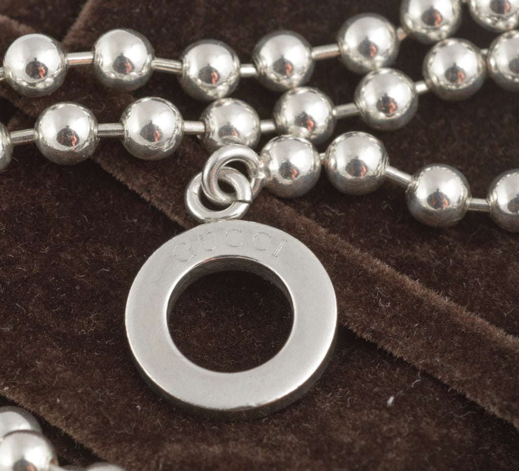 Vintage Gucci Boule sterling silver ball link necklace laid flat on white background showing reverse side of toggle ring with Italian silver hallmarks and Gucci Made in Italy branding