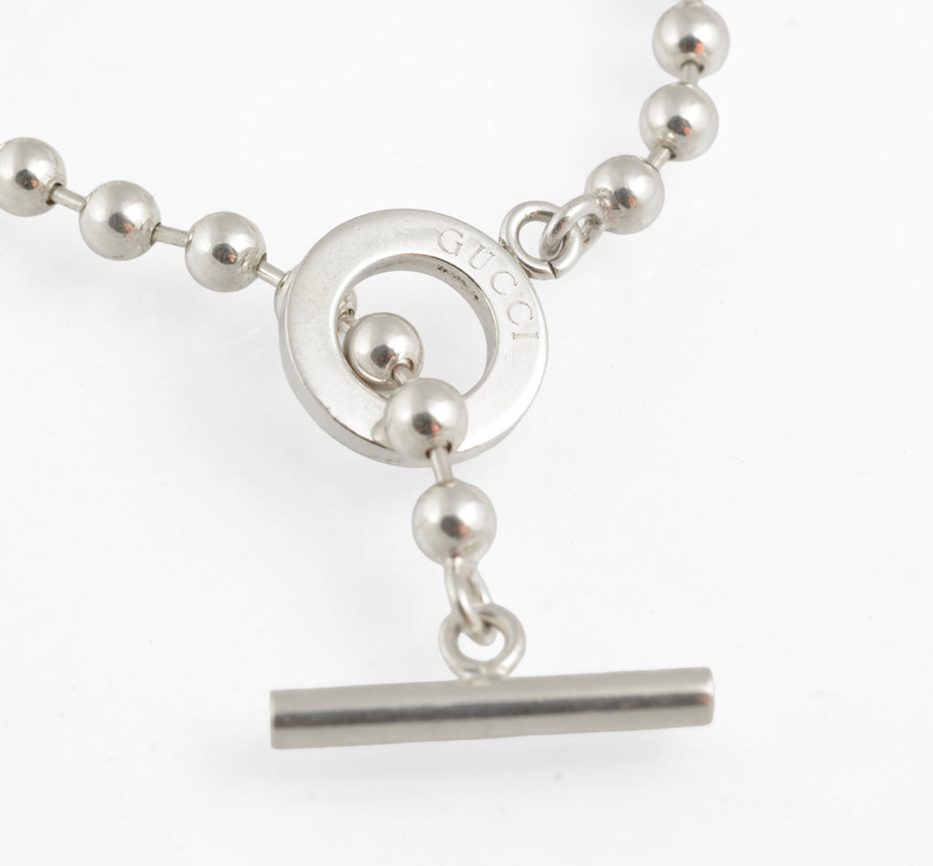 Vintage Gucci Boule sterling silver ball link necklace laid flat on white background showing full length of chain from alternate angle with toggle clasp and T bar