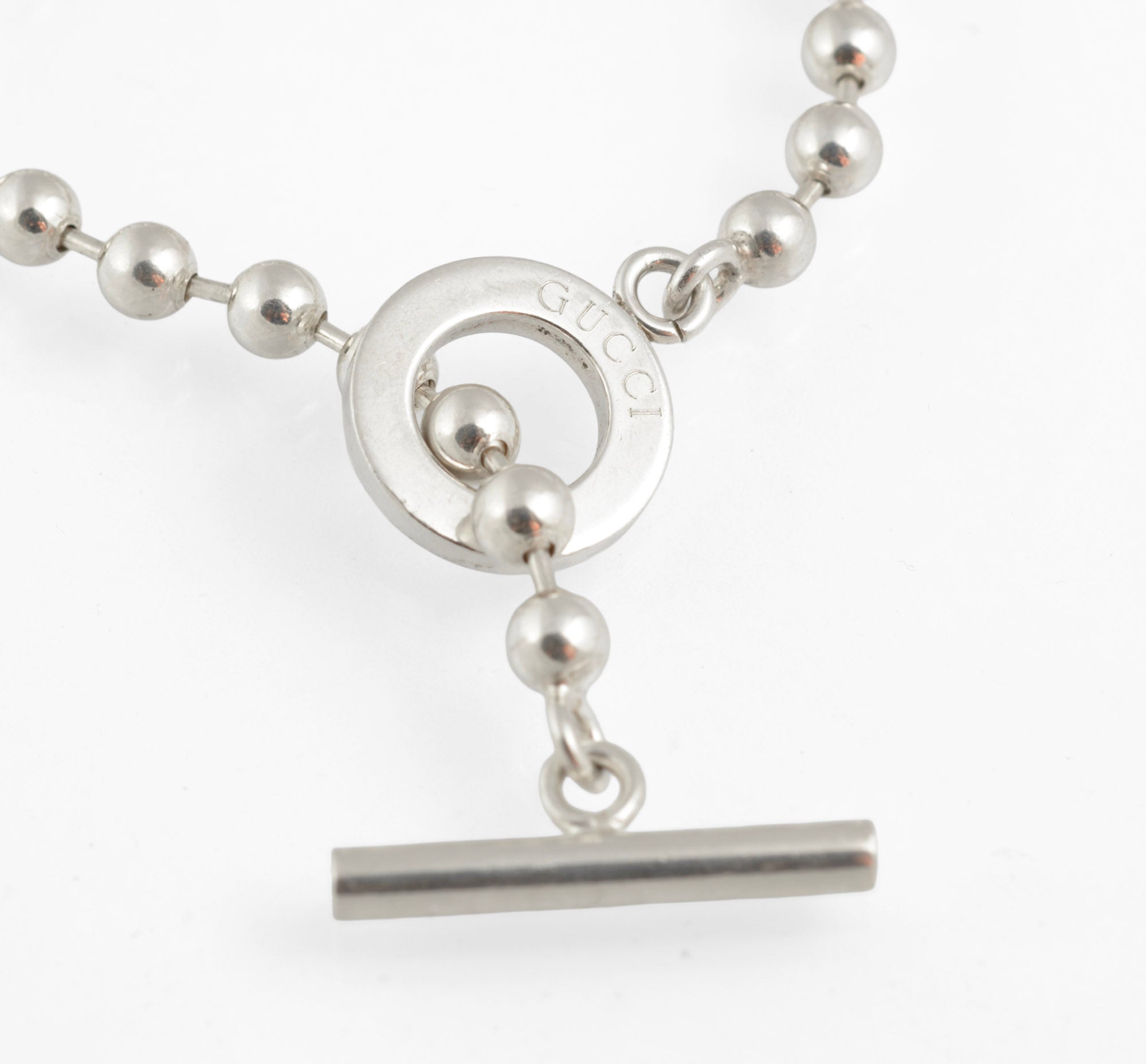 Vintage Gucci Boule sterling silver ball link necklace laid flat on white background showing full length of chain from alternate angle with toggle clasp and T bar