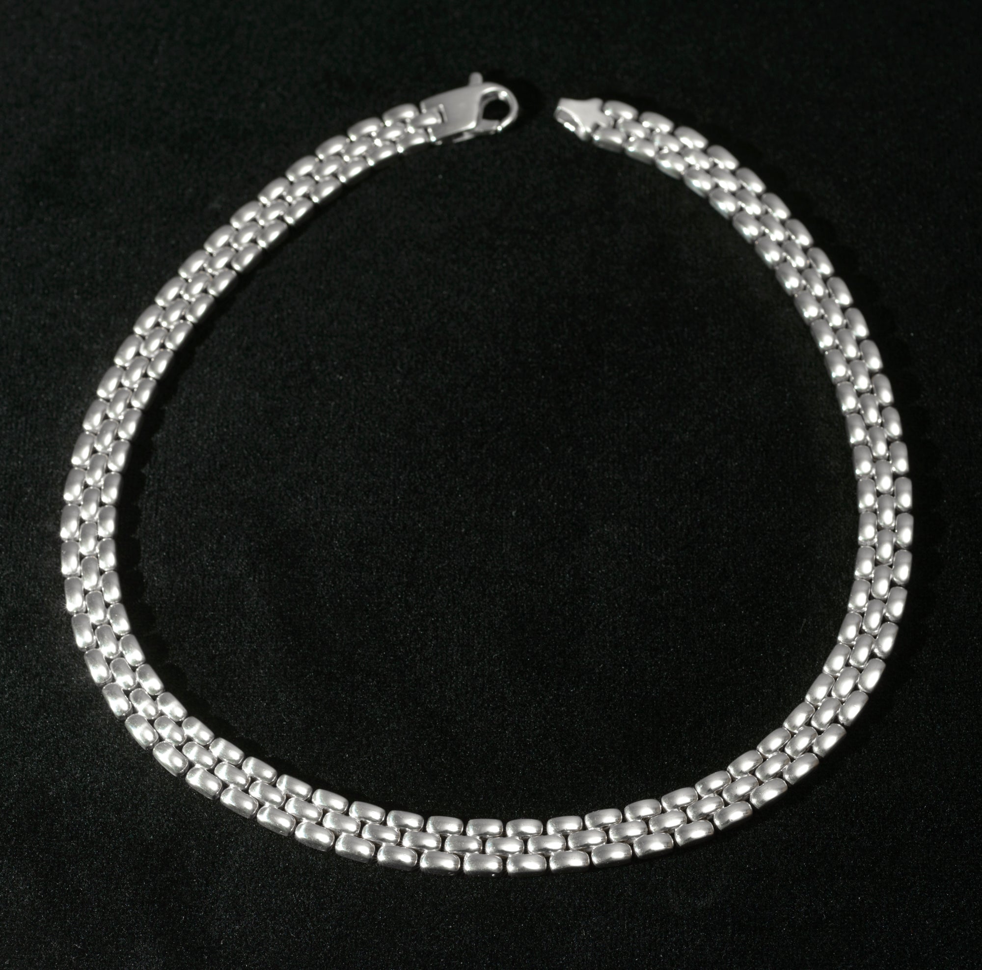 Heavy sterling silver three row brick link necklace laid flat on black background showing full length of necklace with flat lobster clasp