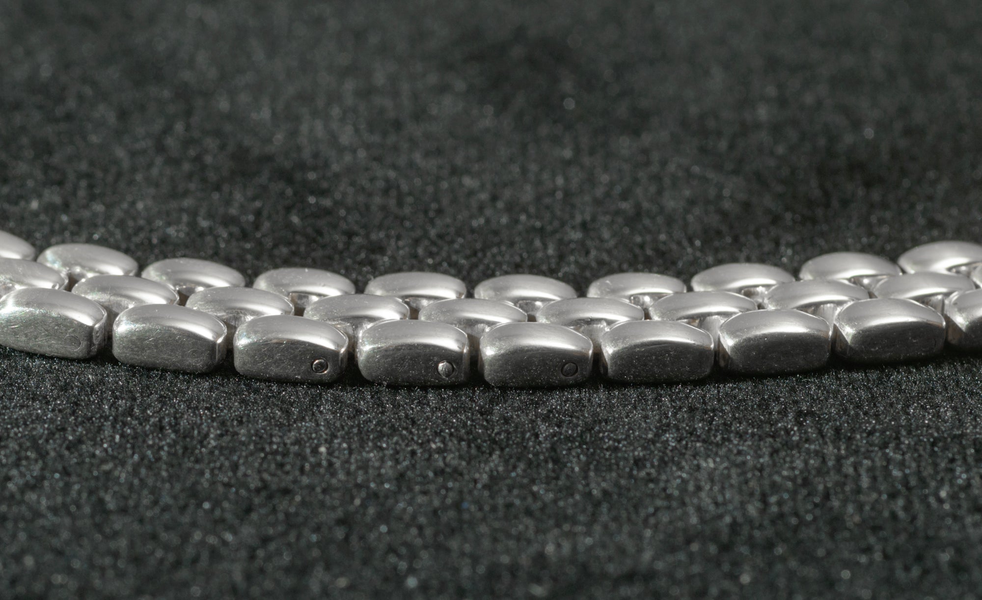Close up of heavy sterling silver three row brick link necklace end fitting on black background showing 925 hallmark stamp and SC pictorial device SC maker's mark