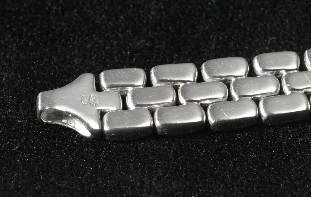 Heavy sterling silver three row brick link necklace laid flat on black background showing angled view of brick link construction and chain profile