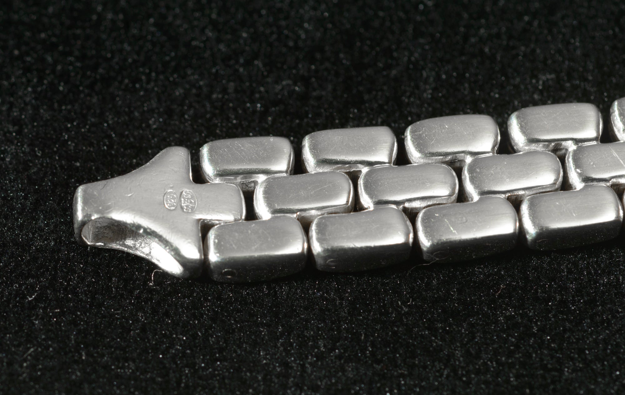 Heavy sterling silver three row brick link necklace laid flat on black background showing angled view of brick link construction and chain profile