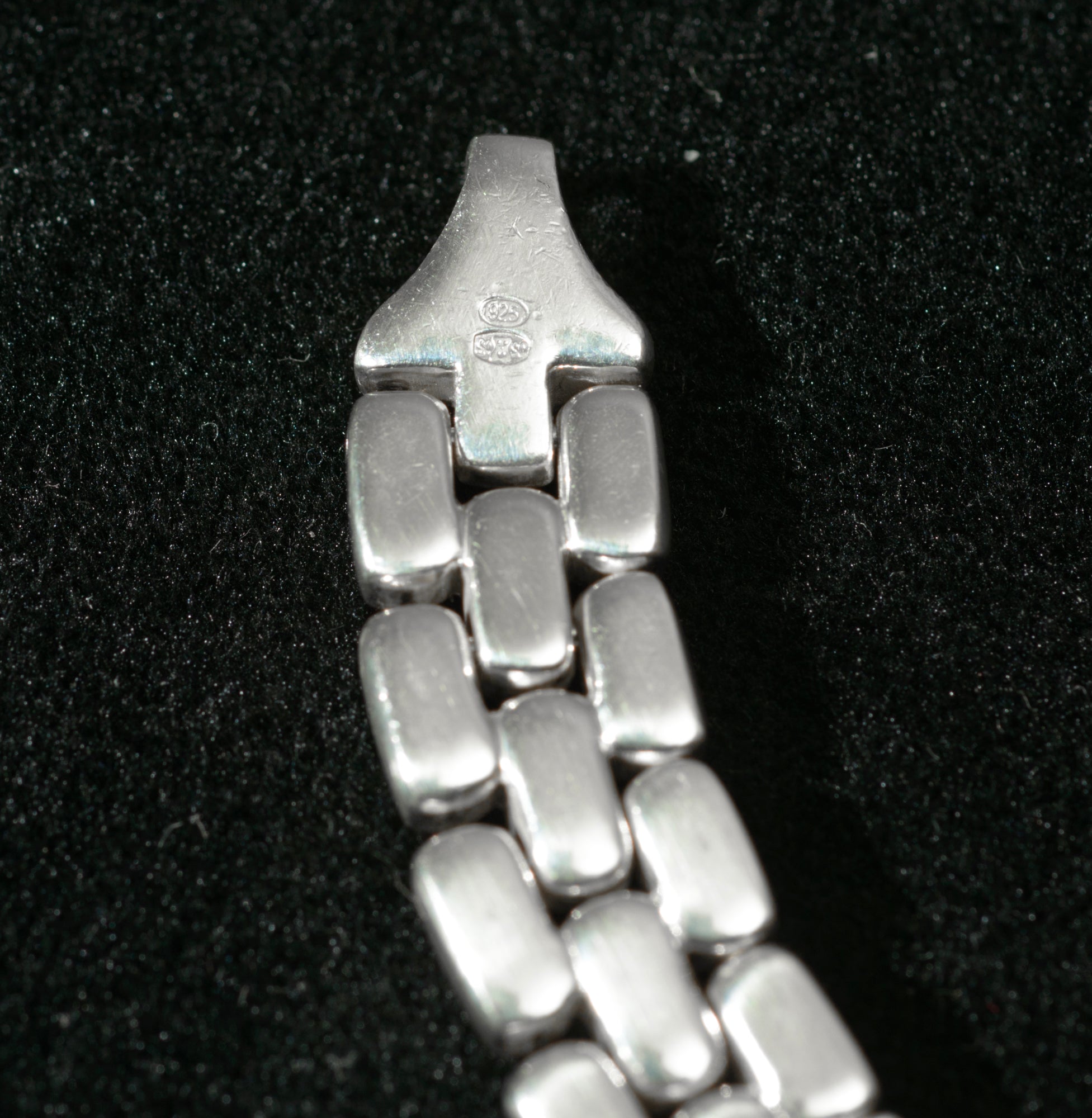 Heavy sterling silver three row brick link necklace laid flat on black background showing full length from alternate angle with clasp end visible