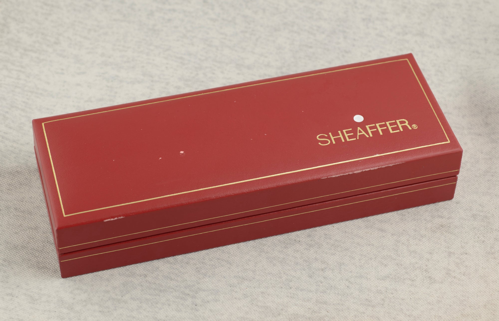 Original Sheaffer red presentation case open with fold out instruction pamphlet showing 0.5mm push button pencil instructions in English French Spanish and German on linen background