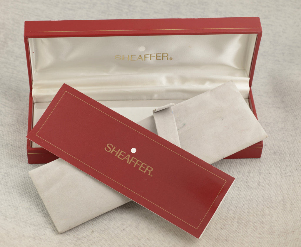 Sheaffer Targa 676 Classic fountain pen Gold Feather finish cap removed and resting on barrel showing 14K inlaid gold nib and black section with metal threads on linen background