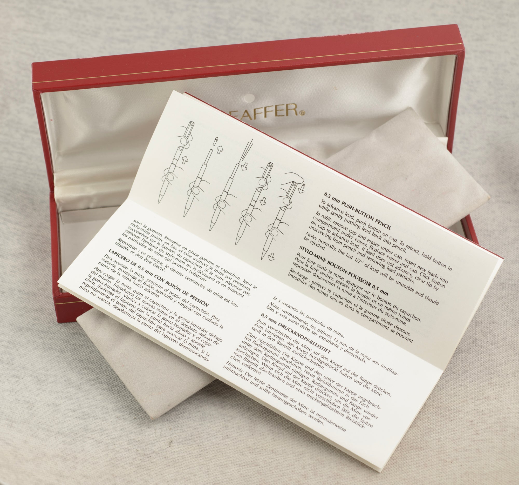 Sheaffer Targa 676 Classic fountain pen Gold Feather finish cap resting on barrel showing close detail of wavy guilloche Gold Feather pattern on cap and barrel on linen background