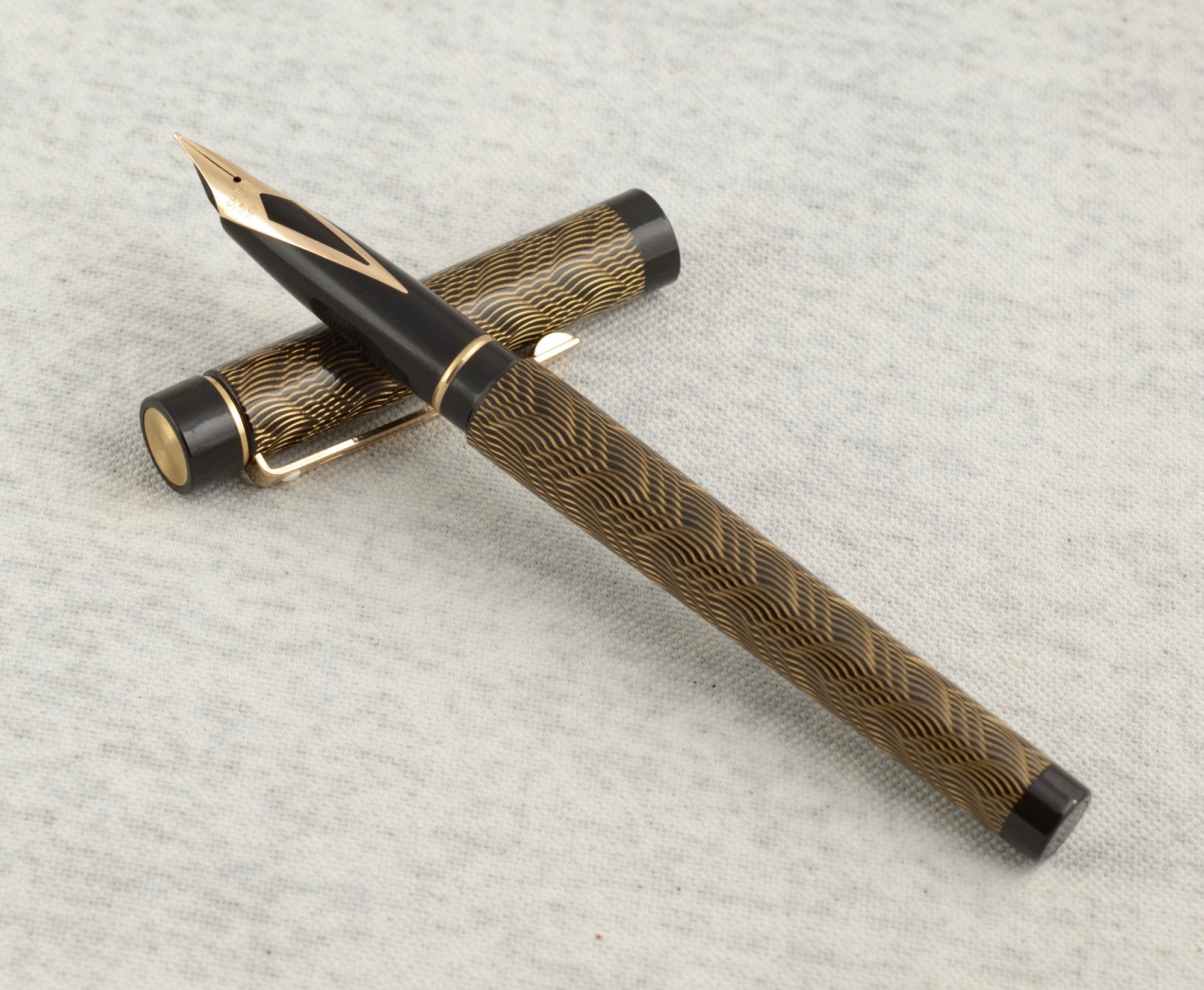 Sheaffer removable converter with red fill aperture alongside Sheaffer Targa 676 Classic fountain pen Gold Feather finish on linen background