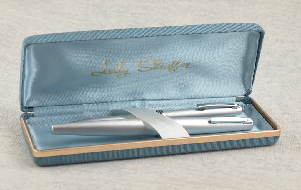 Lady Sheaffer 620 Florentine fountain pen cap removed showing recessed stainless steel nib and barrel with ribbed converter visible alongside cap on linen background