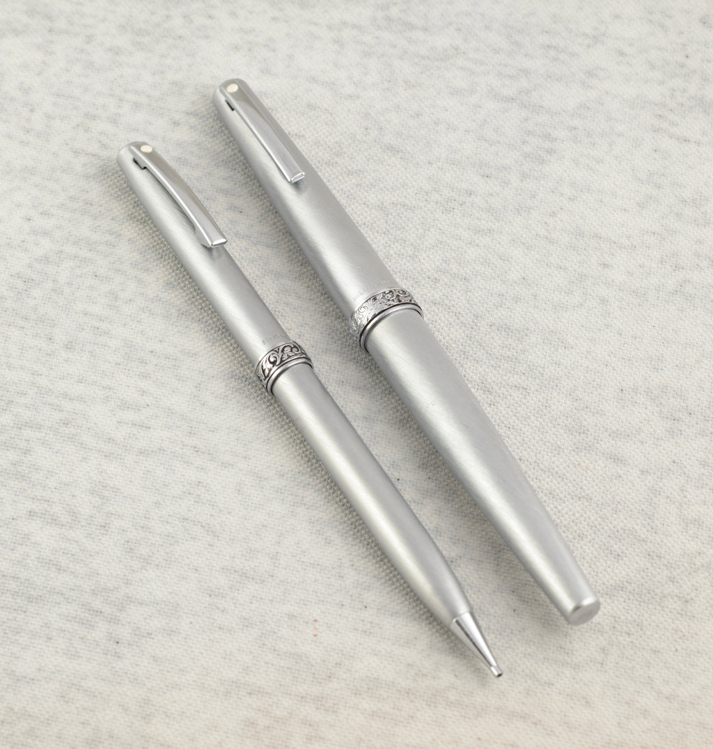 Lady Sheaffer 620 Florentine set disassembled on linen background showing fountain pen cap barrel with converter pencil cap and pencil barrel as four separate components