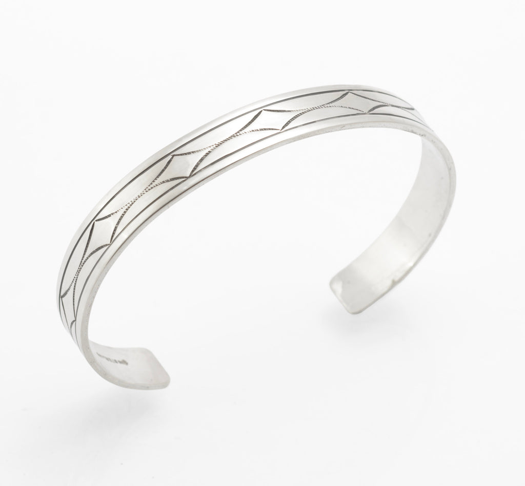 Vintage sterling silver open cuff bangle flat view showing full length of hand engraved geometric star and diamond pattern with hatched detail on white background