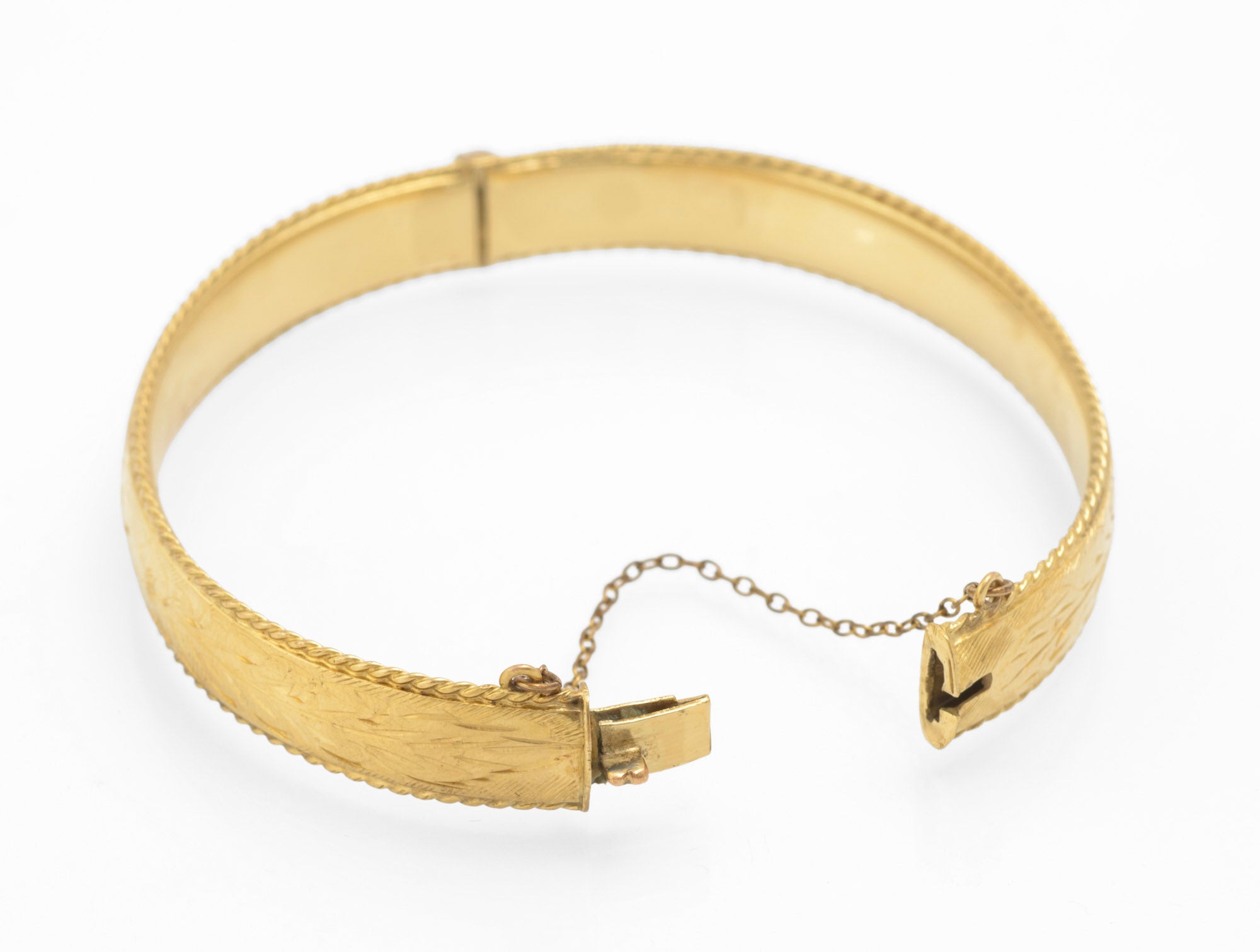 Inside of vintage 1/5 9ct rolled gold hinged bangle showing plain interior and clasp end with safety chain on white background