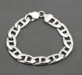 Vintage sterling silver broad mariner link bracelet laid in circle on dark grey background showing flat oval links with central dividing bars and lobster clasp with shaped ribbed terminal