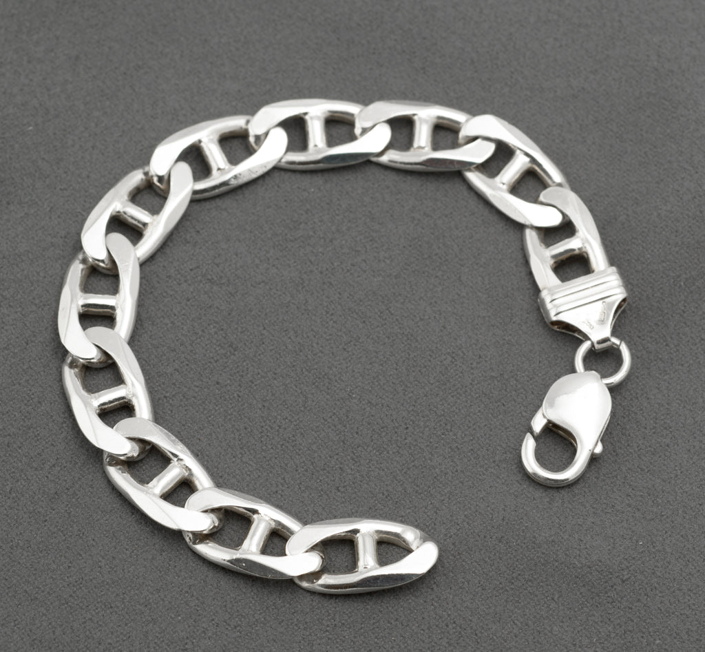 Vintage sterling silver broad mariner link bracelet laid open on light grey background showing full 19.5cm length flat oval links with central bars and lobster clasp unclasped