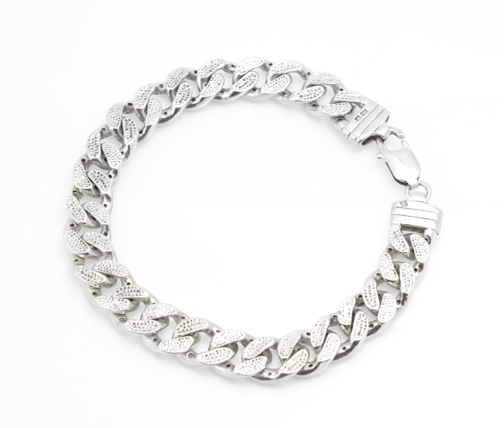 Vintage sterling silver CZ curb chain bracelet worn on wrist, showing scale and fit against dark sleeve
