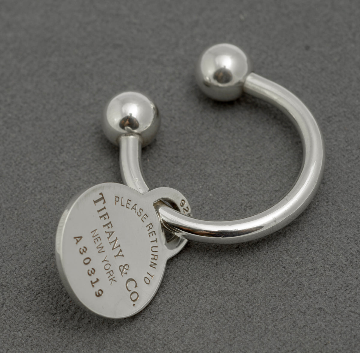 Tiffany and Co sterling silver Return to Tiffany screwball key ring, front view showing oval tag engraved Please Return to Tiffany and Co New York A30319