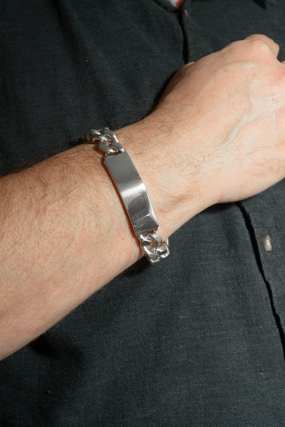 Vintage sterling silver ID bracelet full view on white background showing broad curb links, plain unengraved ID panel and folding box clasp