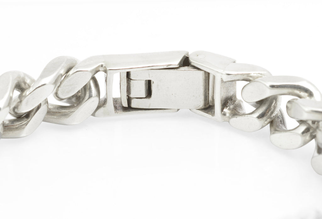Vintage sterling silver ID bracelet clasp open on white background showing internal folding box mechanism and link construction