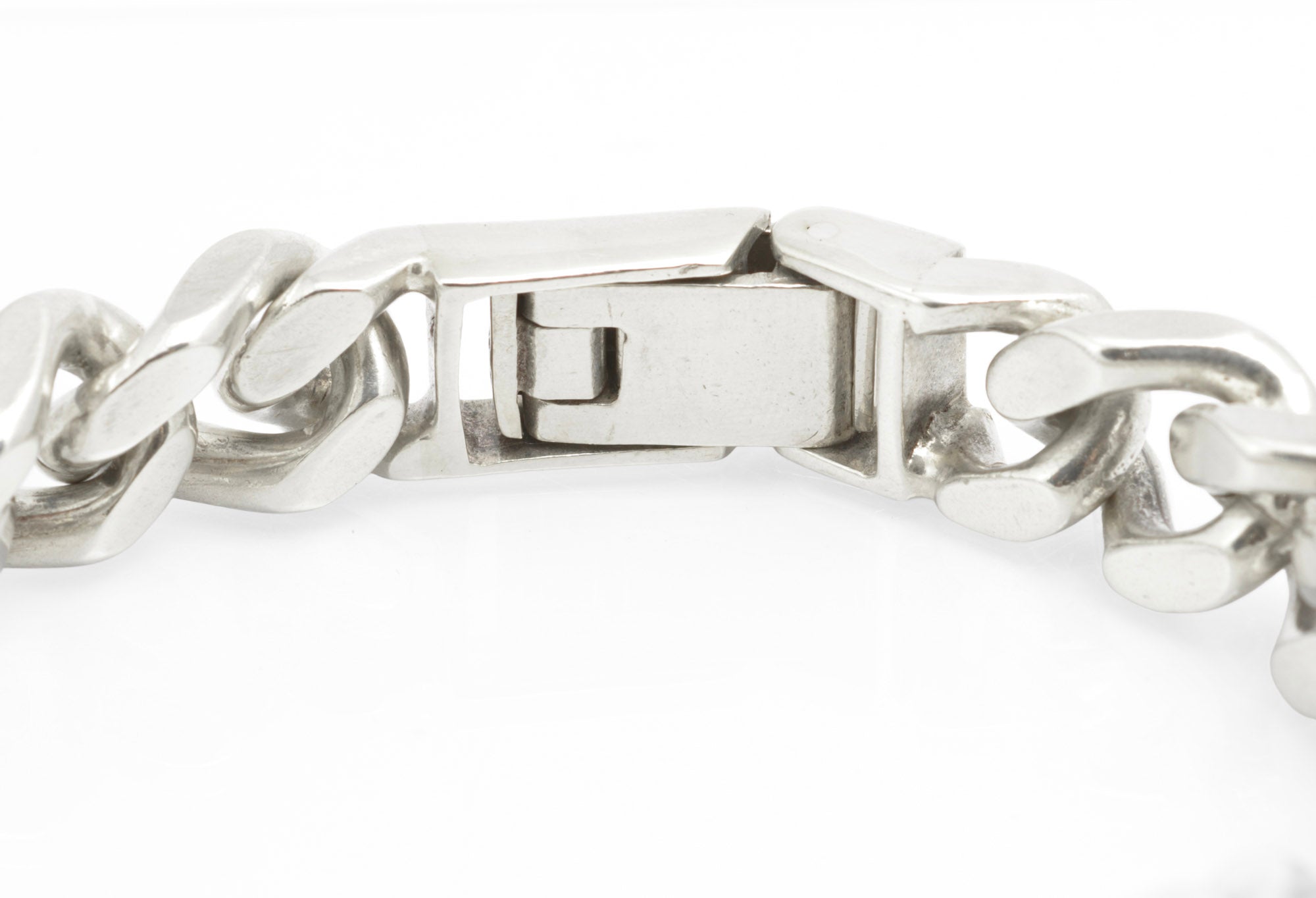 Vintage sterling silver ID bracelet clasp open on white background showing internal folding box mechanism and link construction