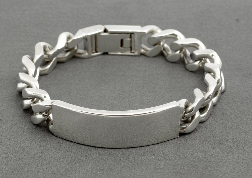 Vintage sterling silver ID bracelet top down view on grey background showing full length, plain ID panel and folding box clasp