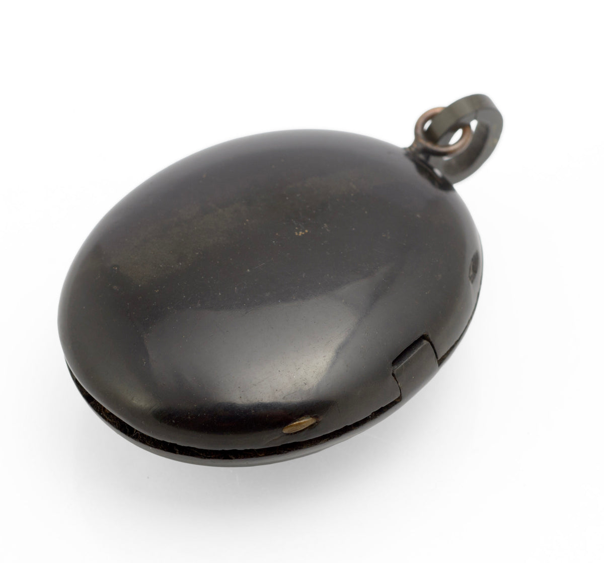 Antique Victorian vulcanite mourning locket angled front view showing olive brown tone to upper surface and raised decorative panel