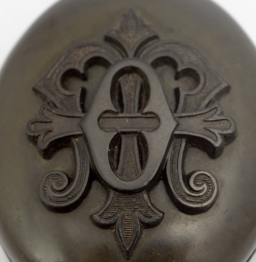 Antique Victorian vulcanite mourning locket open view second angle showing brass retaining rings and interior foliate engraving in both halves