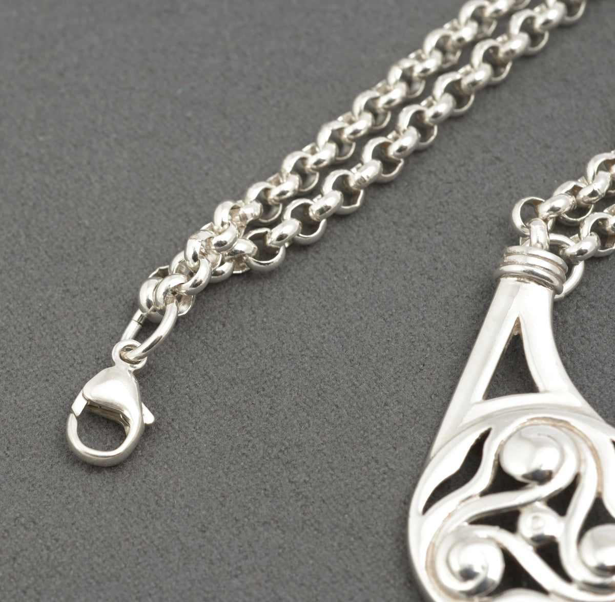 Vintage Ola Gorie sterling silver necklet detail of double rolo chain transitioning to single extension section on grey background