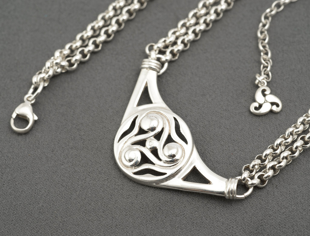 Vintage Ola Gorie sterling silver necklet close up of triskelion centre on grey background showing polished scroll forms and openwork detail