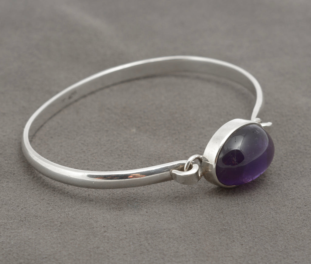 Vintage sterling silver amethyst cabochon bangle, close view of oval stone, bezel and silver band