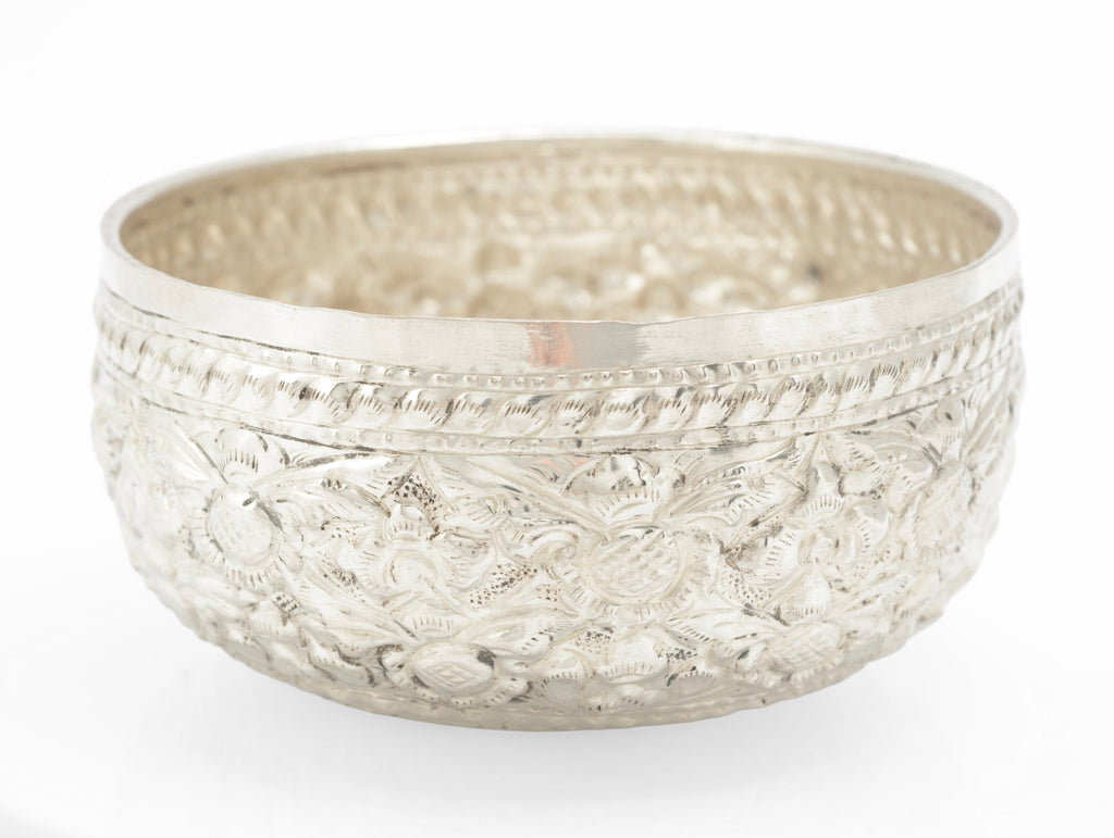 Detail of raised and chased floral decoration on a handmade Thai silver offering bowl